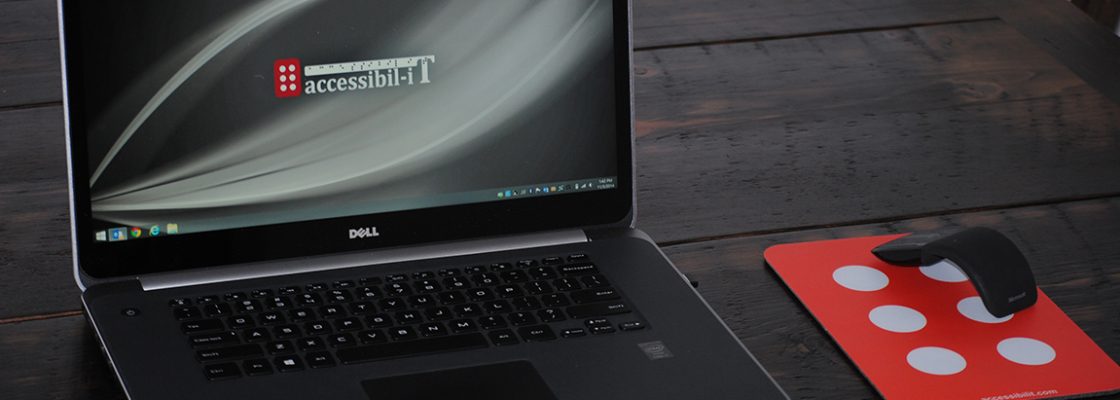 Photograph of a laptop and mouse pad with the Accessibil-IT logos